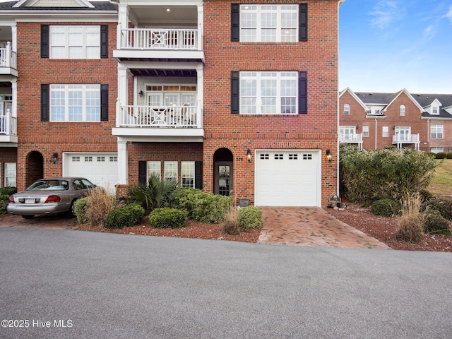 view of front of property featuring driveway, brick siding, and an attached garage