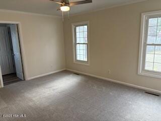 unfurnished bedroom with carpet flooring, baseboards, visible vents, and crown molding