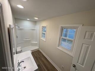 bathroom featuring a sink, baseboards, walk in shower, and wood finished floors