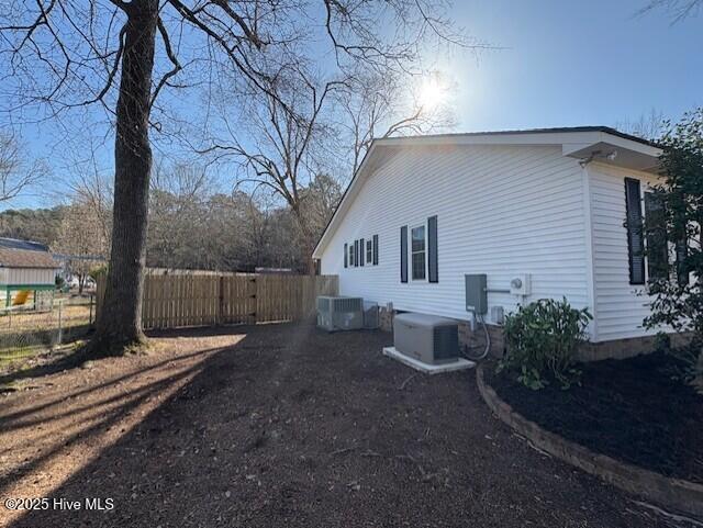 view of home's exterior featuring central AC unit and fence