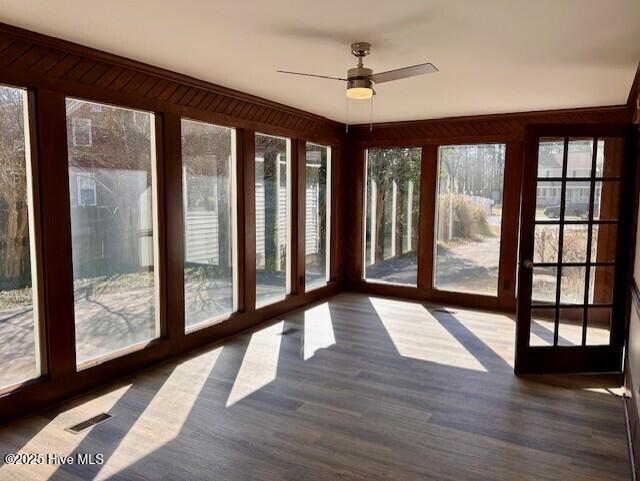 unfurnished sunroom featuring visible vents and a ceiling fan