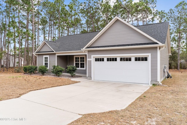 view of front of home with concrete driveway, a garage, and a shingled roof