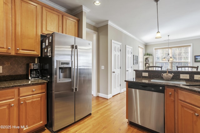 kitchen featuring brown cabinetry, ornamental molding, stainless steel appliances, and backsplash