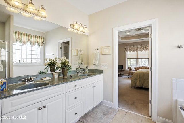 ensuite bathroom with connected bathroom, tile patterned flooring, a sink, and double vanity