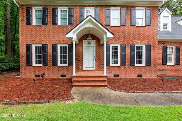 view of front of property featuring brick siding, crawl space, and a shingled roof