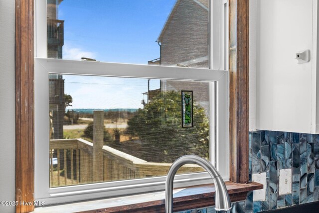 kitchen with stainless steel appliances, a sink, visible vents, backsplash, and dark countertops