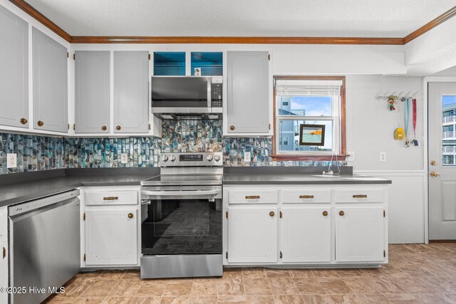 kitchen featuring ornamental molding, appliances with stainless steel finishes, and a healthy amount of sunlight