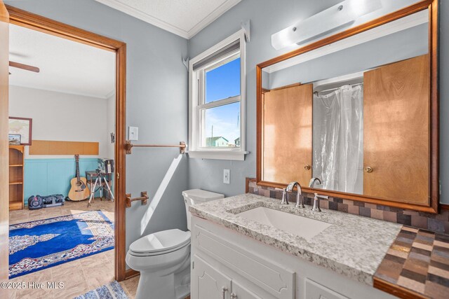 office with a textured ceiling, wainscoting, a ceiling fan, and crown molding