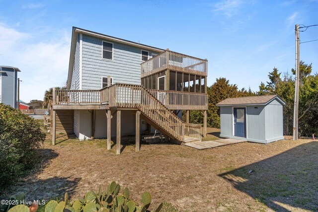 back of house with a storage shed, stairway, an outdoor structure, and a sunroom