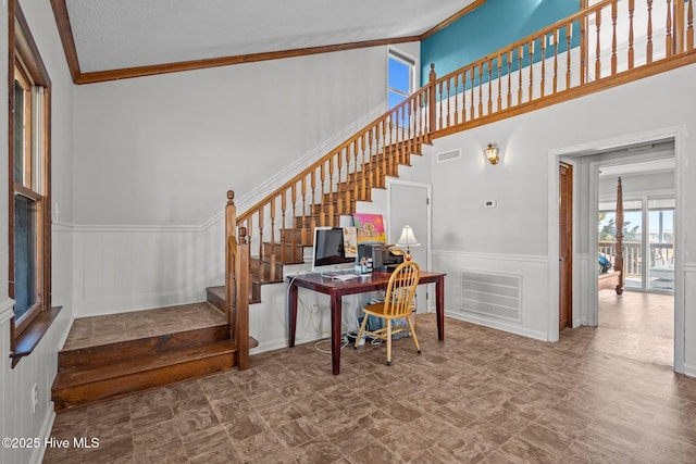 stairs with a wainscoted wall, visible vents, and a decorative wall