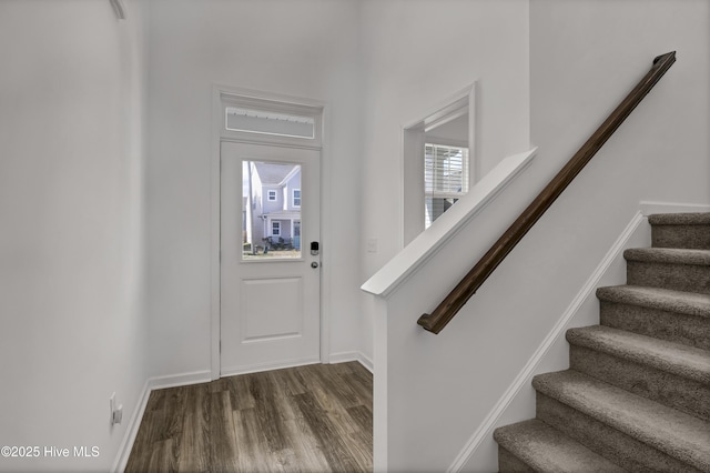 foyer featuring stairs, wood finished floors, and baseboards