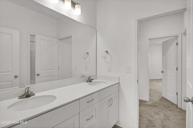 bathroom with double vanity, a sink, and baseboards