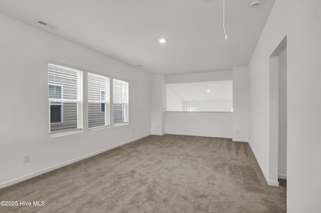 carpeted empty room featuring baseboards, visible vents, and recessed lighting