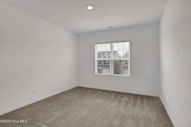 carpeted empty room with visible vents and baseboards