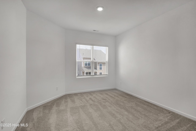 spare room with recessed lighting, carpet, visible vents, and baseboards