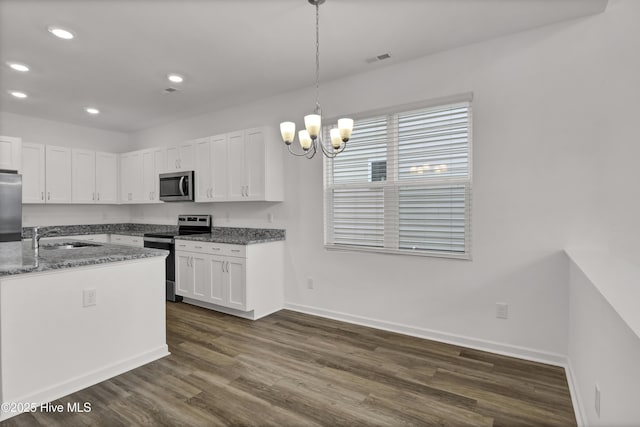 kitchen with a sink, visible vents, white cabinetry, appliances with stainless steel finishes, and dark wood finished floors