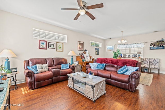 living room with ceiling fan with notable chandelier, wood finished floors, and baseboards