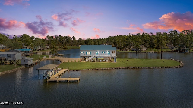 exterior space with stairway, a lawn, a water view, and boat lift