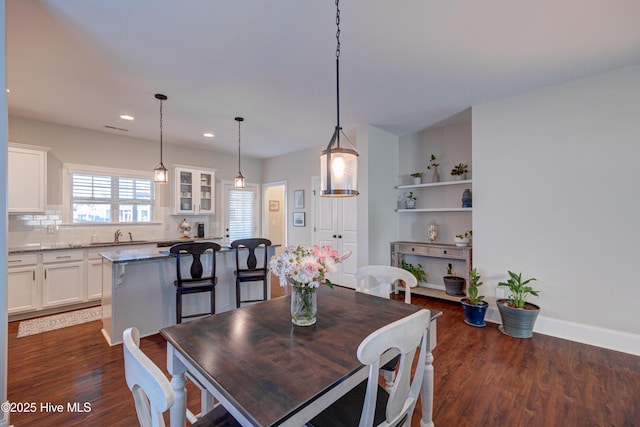 dining space with recessed lighting, dark wood finished floors, and baseboards