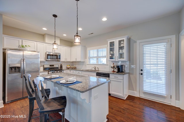 kitchen with appliances with stainless steel finishes, dark wood-style flooring, and white cabinetry