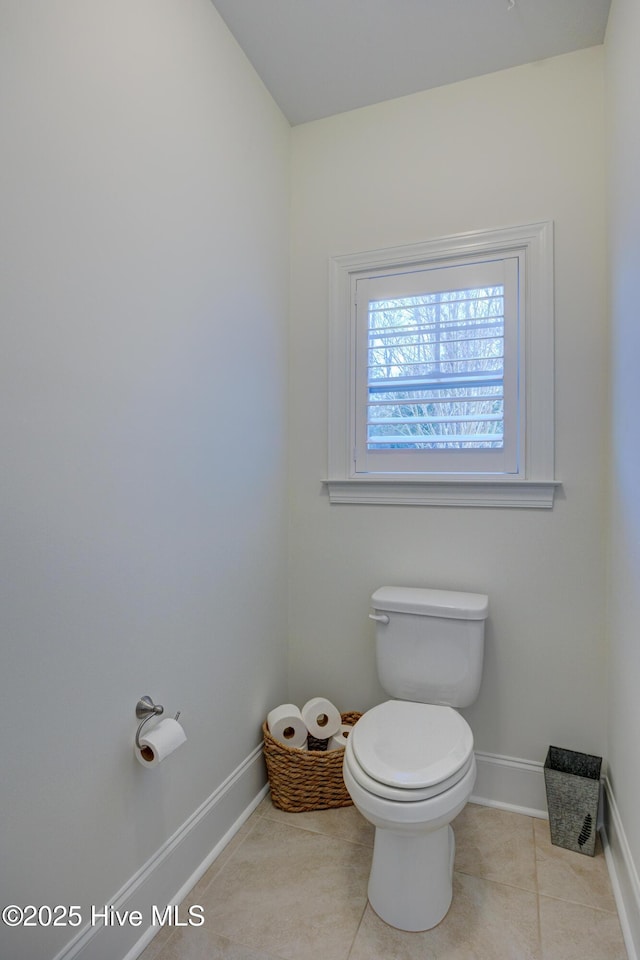 bathroom featuring toilet, baseboards, and tile patterned floors