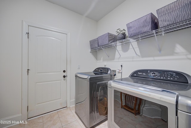 laundry room featuring light tile patterned floors, laundry area, and separate washer and dryer