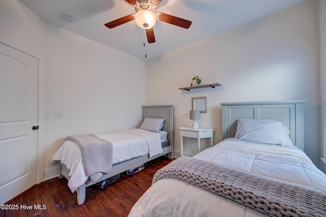 bedroom featuring dark wood-type flooring, a ceiling fan, and baseboards