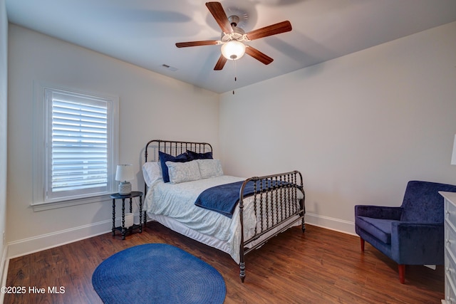 bedroom featuring visible vents, baseboards, ceiling fan, and wood finished floors