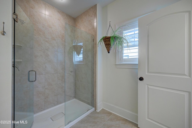 bathroom featuring a shower stall, baseboards, and tile patterned floors