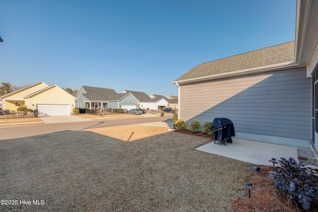 view of yard featuring a residential view and a detached garage