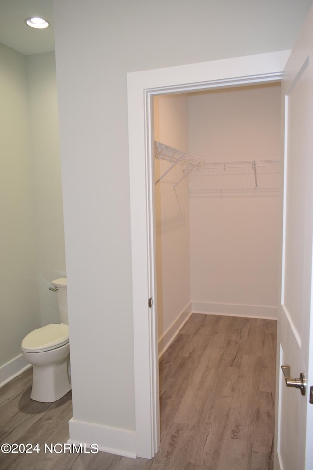 walk in closet with wood finished floors