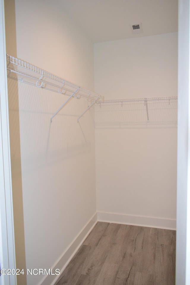 spacious closet featuring visible vents and wood finished floors