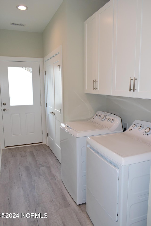 laundry room with recessed lighting, visible vents, light wood-style floors, cabinet space, and washing machine and clothes dryer