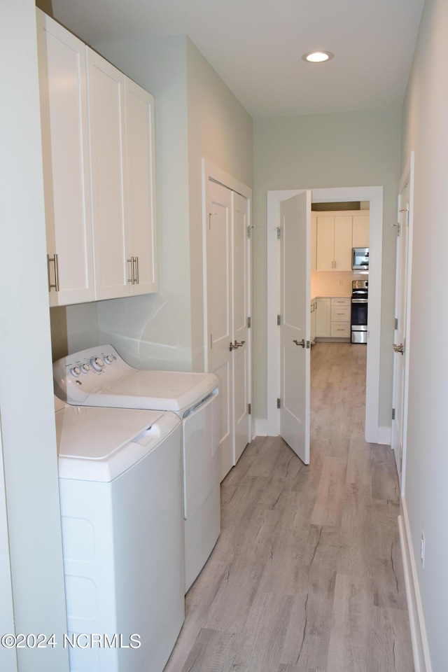 washroom featuring recessed lighting, separate washer and dryer, baseboards, cabinet space, and light wood finished floors