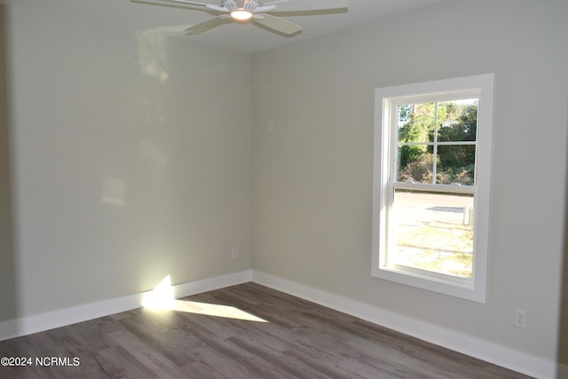 spare room featuring dark wood-style floors, ceiling fan, and baseboards