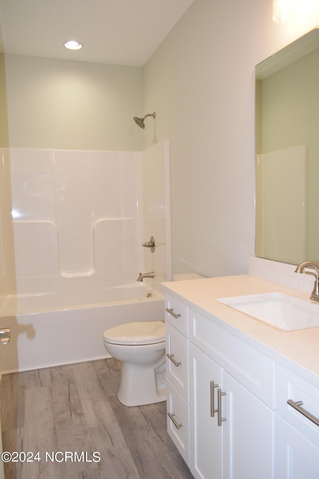 bathroom with shower / tub combination, vanity, toilet, and wood finished floors