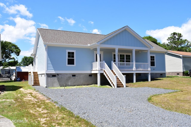 view of front of home with crawl space, covered porch, stairway, and a front yard