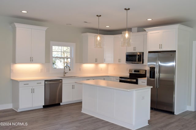 kitchen featuring stainless steel appliances, light countertops, decorative backsplash, white cabinets, and a sink