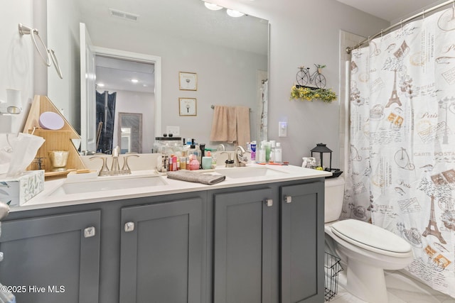 full bathroom featuring toilet, double vanity, visible vents, and a sink