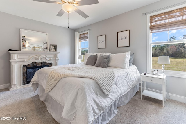 bedroom with carpet flooring, a fireplace, baseboards, and ceiling fan