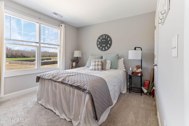 bedroom with light colored carpet, visible vents, and baseboards