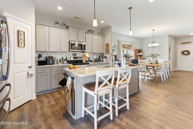 kitchen featuring a sink, visible vents, appliances with stainless steel finishes, gray cabinets, and tasteful backsplash