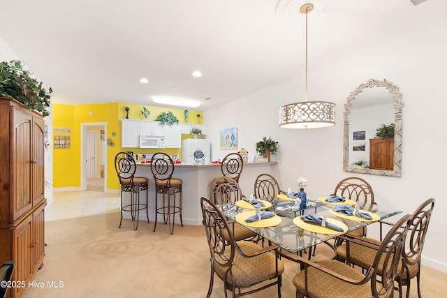 dining space with light carpet, light tile patterned floors, baseboards, and recessed lighting