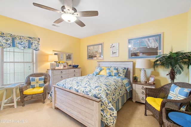 bedroom featuring visible vents, ceiling fan, and light carpet