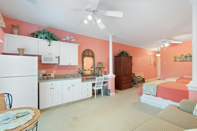 bedroom with light carpet, ornate columns, a sink, and freestanding refrigerator