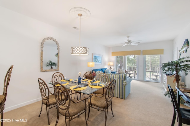 dining room with light carpet, ceiling fan, visible vents, and baseboards