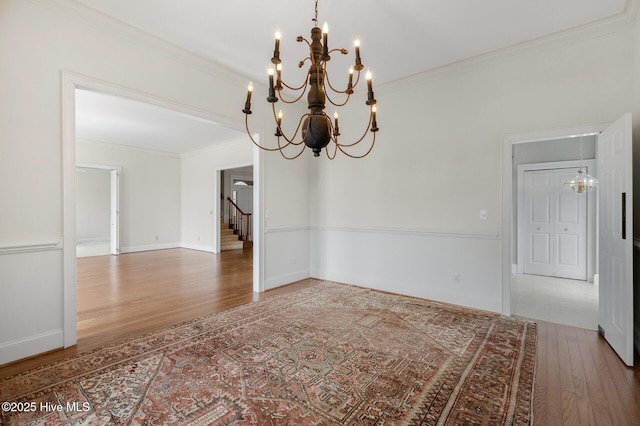 unfurnished room featuring crown molding, baseboards, and wood finished floors