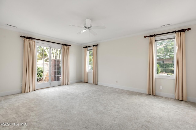 carpeted spare room with ornamental molding, visible vents, and baseboards