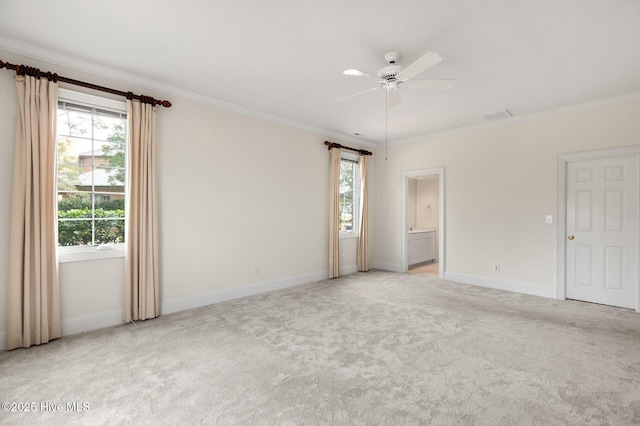 empty room with visible vents, baseboards, a ceiling fan, light colored carpet, and crown molding