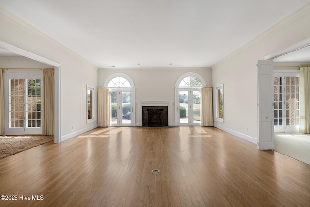 unfurnished living room with a fireplace, baseboards, and wood finished floors